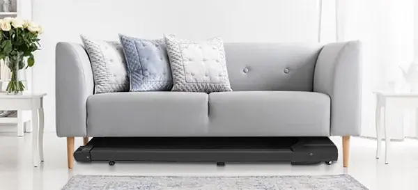 Flat walking pad slid under a sofa for storage (retailer image)