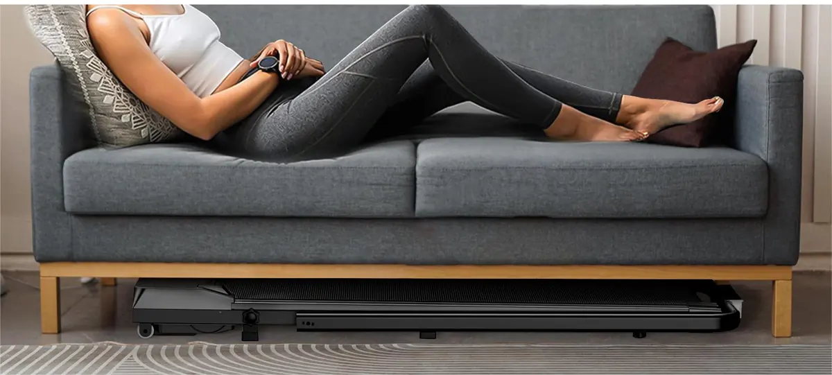 Walking pad stored flat under a sofa, showing its low height (retailer image)
