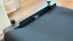 Walking pad belt and metal frame partly unpacked from bubble wrap on a wooden floor